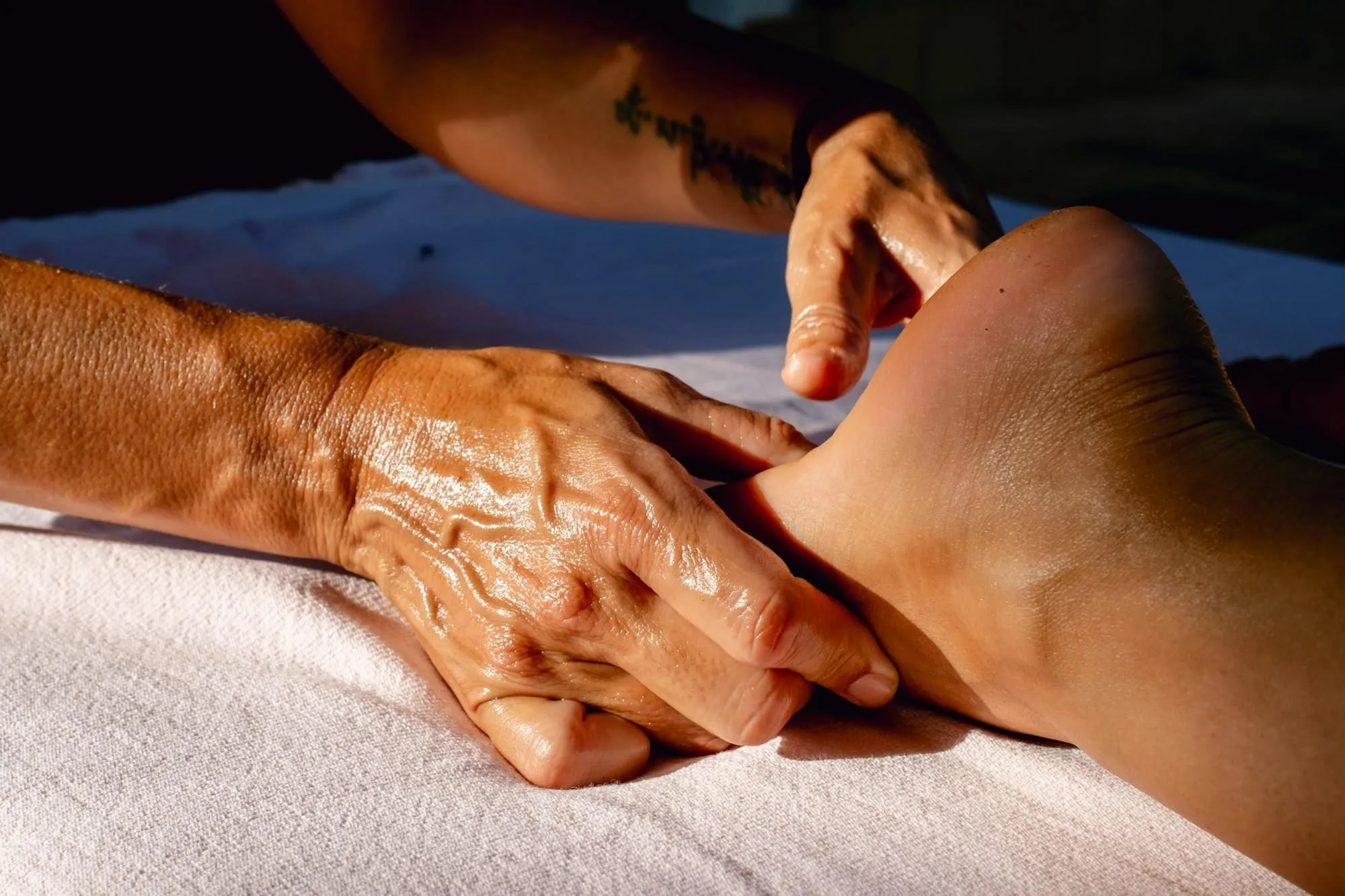 Des mains qui apprennent les gestes du massage sur une jambe