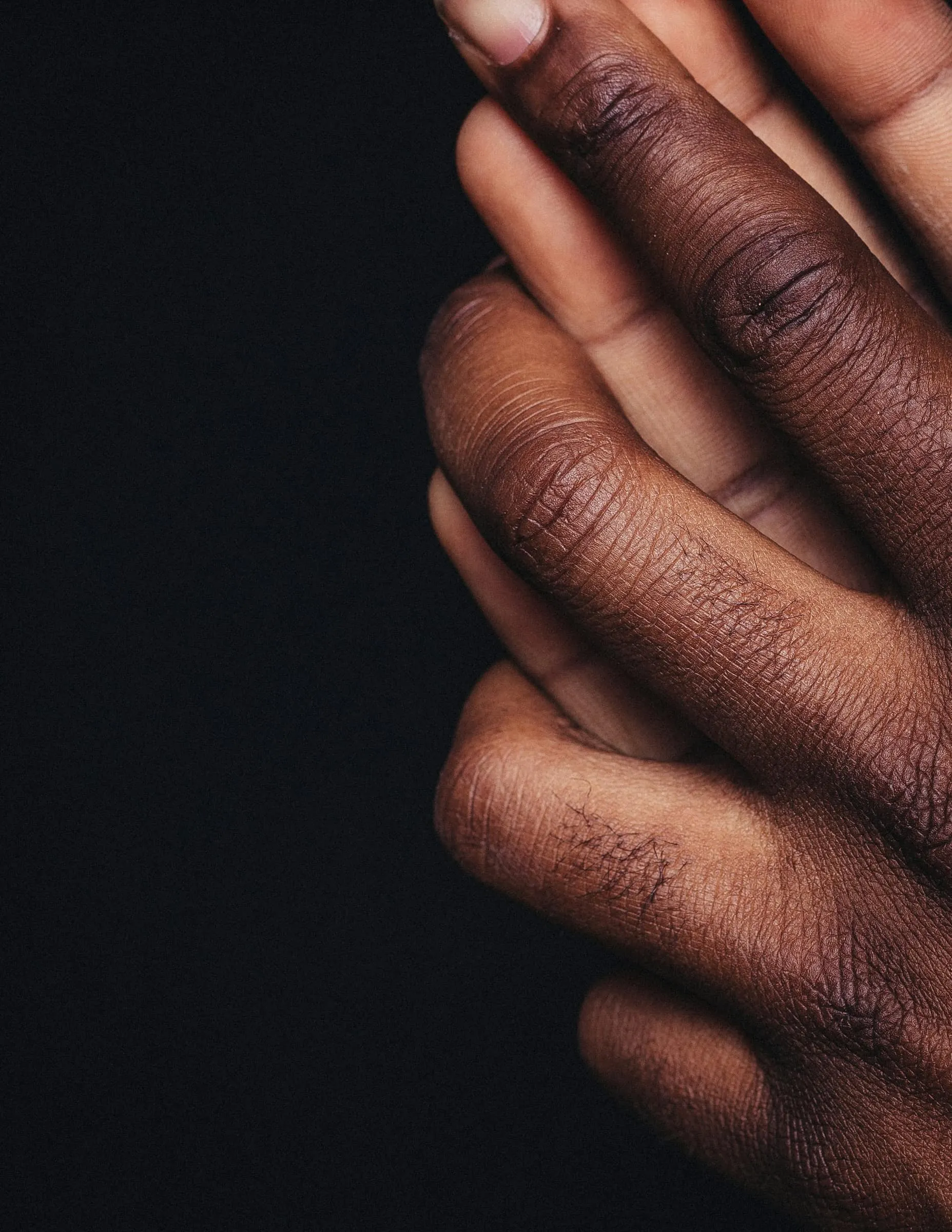 Deux mains enlacées sur un fond sombre