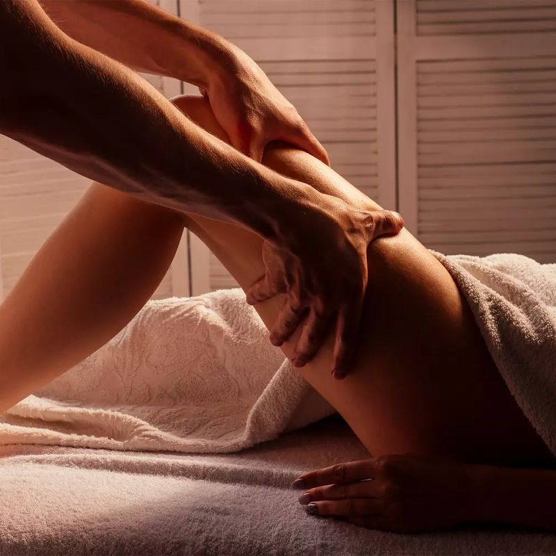 Mains posées sur la jambe, dans une lumière chaude et tamisée